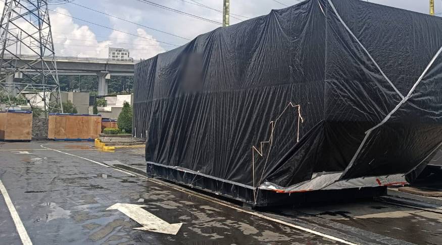 Equipo industrial de gran tamaño envuelto por completo en película VCI negra sobre su base de acero, listo para el traslado